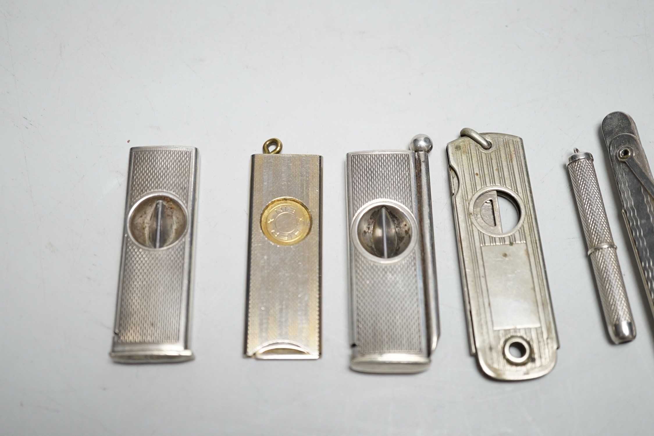 Two silver cigar cutters, a plated tamper and two other cutters / piercers